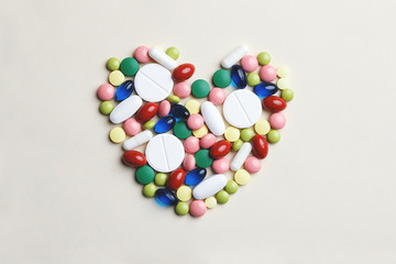 heart made of assorted multi-colored pills, capsules and tablets, heart  disease treatment, top view, flat lay