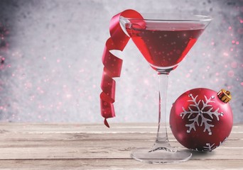 Glass of red wine and Christmas decoration on background