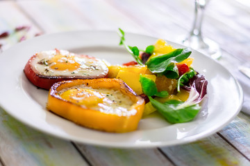 fried eggs with peppers and tomatoes on a white plate