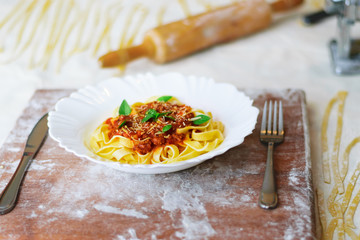 Italian home made pasta. Made by hand spaghetti on the flour table. fresh pasta. Italian kitchen. Italian food. Flour egg ingredients.