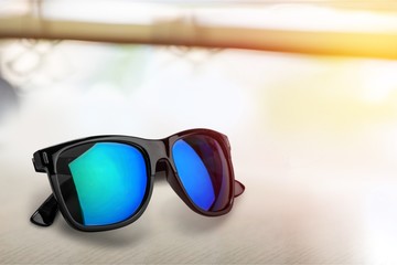 Sunglasses on sandy beach background