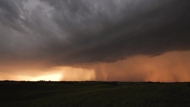 Rainstorm with lightning across the plains during sunset.