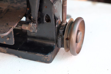 Close-up part of an old sewing machine and detail on adjust  thread , free-wheeling balance wheel