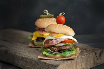  Two hamburgers and french fries on brown paper . hamburgers with meat, cheese, onion and salad 