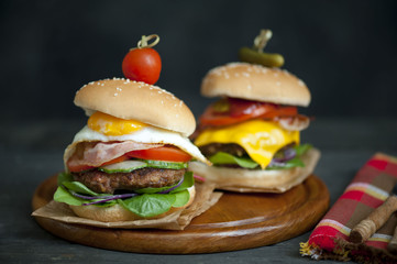  Two hamburgers and french fries on brown paper . hamburgers with meat, cheese, onion and salad 