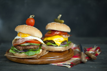  Two hamburgers and french fries on brown paper . hamburgers with meat, cheese, onion and salad 
