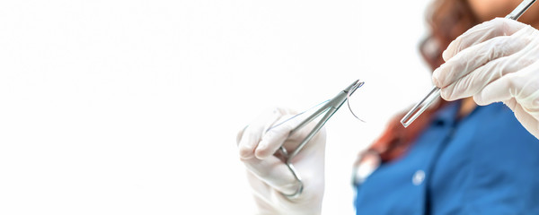 Doctor holding surgical forceps suture needle, suturing material