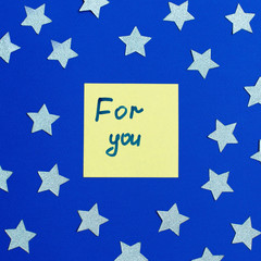 Notes with words For you on the blue background and the stars around