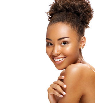 Young girl touching her healthy skin. Photo of smiling african american girl on white background. Youth and skin care concept