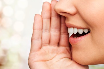 Close up portrait of a smiling skin care woman whispers (tells