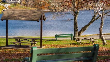 two sexy benches in autumn park, water in background
