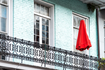 New Orleans, USA Blue colorful turquoise color painted balcony with red umbrella in downtown...