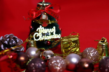 Fototapeta na wymiar クリスマスツリーとたくさんのプレゼントなどのカラフルなクリスマスの装飾(赤背景)