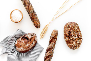 Brown bread. Fresh rustic homemade bread and loaf on tablecloth decorated with ears and flour on...