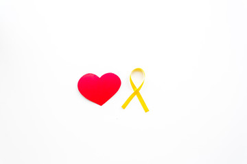 Endometriosis. Gynecological diseases concept. Symbolic yellow ribbon near heart sign on white...