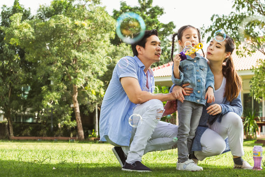 Happy Asian Family Playing In Garden Blowing Bubble, Happy And Smile