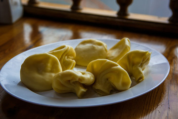 The national dish of Georgian cuisine is khinkali. A small child's hand touches food