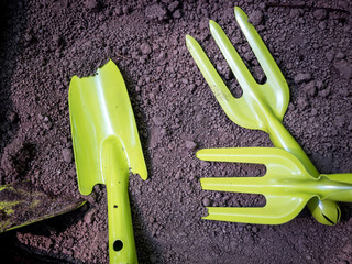 Gardening tools on fertile soil texture background