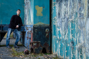 Portrait of young man stand in blue wall corner