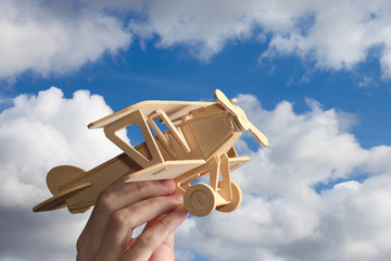 Toy airplane in hand - a symbol of travel and dreams.