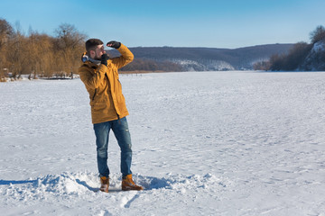 Vaper man standing in winter day and smoking e-cigarette