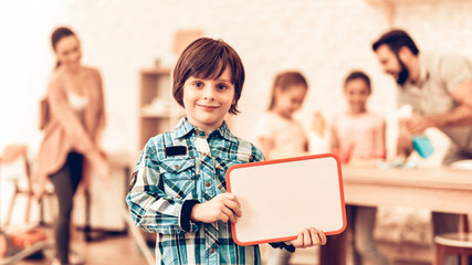 Little Boy Showing Blank Board near Cute Family