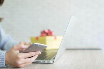 close up young woman using smartphone for selecting special code discount of cyber monday and using laptop computer for choosing item on marketplace website , online shopping season concept