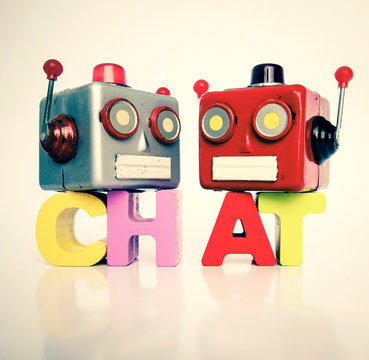 two retro robot heads chatiing isolated on white