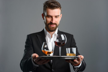 Smiling man serving alcoholic drinks