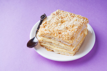 Puff cake with cream Napoleon Millefeuille vanilla slice color on purple background.