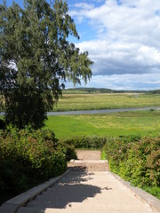 A small river flows through a large field