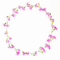 Round frame with pink flowers on white background. Flat lay, Top view. Flowers concept.