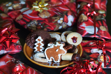 Obraz na płótnie Canvas Ginger bread cookies and Christmas gifts. Christmas decorative paper. Gold and red ribbons. 