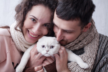 Fototapeta na wymiar Couple Taking Playing With Pet Cat At Home