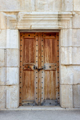 Front shoot of ancient civilization made wooden door on historical stone building