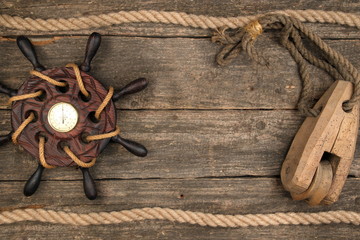Old ship steering wheel,compass and rope. Travel and marine engraving background.Sea trip concept. Vintage and retro style.