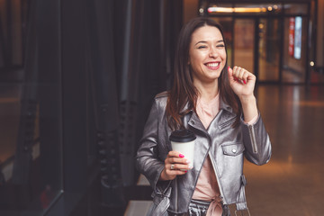 Happy woman holding takeaway coffee