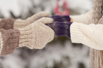 Couple holding each other's hands, the winter goes on the road, enjoying a stroll, a love couple. Husband and wife are going through the park holding hands in the winter.