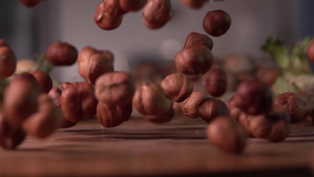 hazelnuts falling on cutting wood board ,slow motion 240 fps, shot on sony rx 10