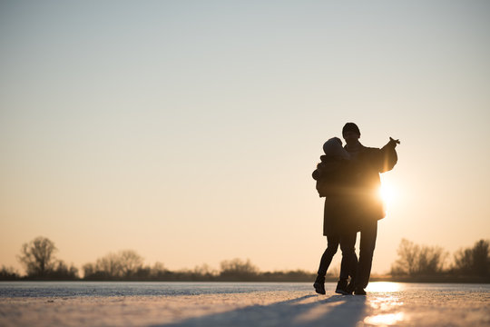 Romantic couple dancing on frozen lake