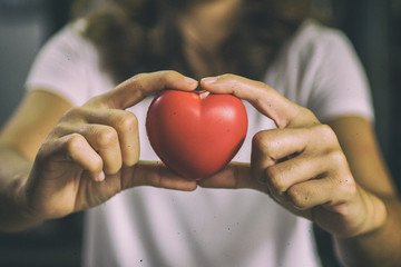 Red heart in woman hands