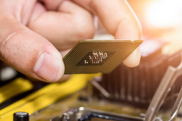 Technician plug in CPU microprocessor to motherboard socket