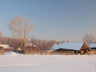 Sunset. Old traditional Russian wooden house. Winter, Russia, Ural, Perm Region