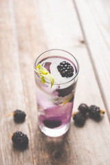 Blackberry mojito cocktail on the wooden background. Selective focus. Shallow depth of field.