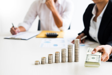 stacks of coins business accounting with saving money  concept calculator counting, making notes at home, hand is writes in a notebook. Stacked coins arranged, graph, chart and pen