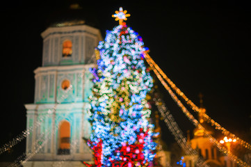 Blurred background. Christmas tree decorated with lights  at night.