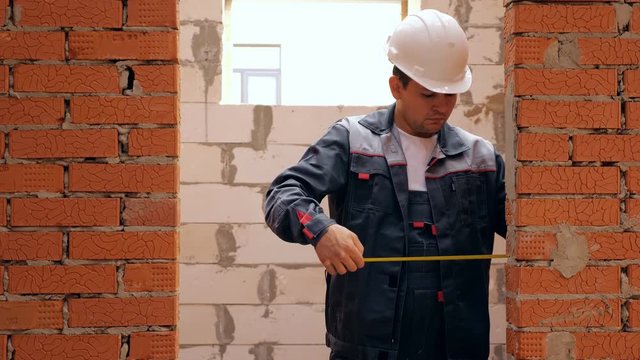Adult building measuring width of doorway
