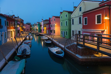 Fototapeta na wymiar Old colorful houses and boats at night in Burano, Italy.