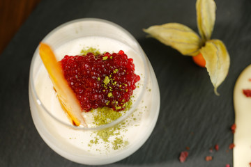 Delicious dessert cold cream with a pomegranate on a tables