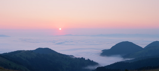 Fototapeta na wymiar Pink dawn above the clouds in the mountains